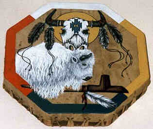Octagonal drum painted. 
The border painted with colors of the Four Directions: 
East ochre, South black-blue, West red and North white. 
From the left the White Buffalo leans over the Sacred Pipe 
decorated with a white feather attached to the pipe with a 
leather string. The right horn of the buffalo in the center 
of the drum. At the top a Buffalo Scull sun shield. Two 
feathers, decorated with strings attached to each buffalo horn. 
The strings tangling down over the white buffalo and into the 
open space West. The roots of the horns decorated with rings. 
A weaving motive adorns the forehead of the buffalo scull.